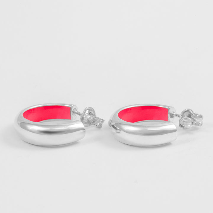 Orecchini a cerchio bombati in argento sterling 925 smaltato a mano internamente di colore rosa fluo. Prodotti in Italia. Réveli